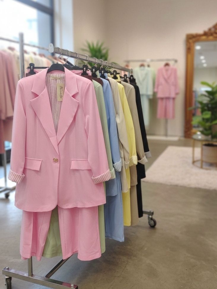 Un Tailleur-Pantalon Coupe Large. 
Blazer Avec Un Bouton Doré Et Pantalon Avec Ceinture. La Doublure À Rayures (x4)